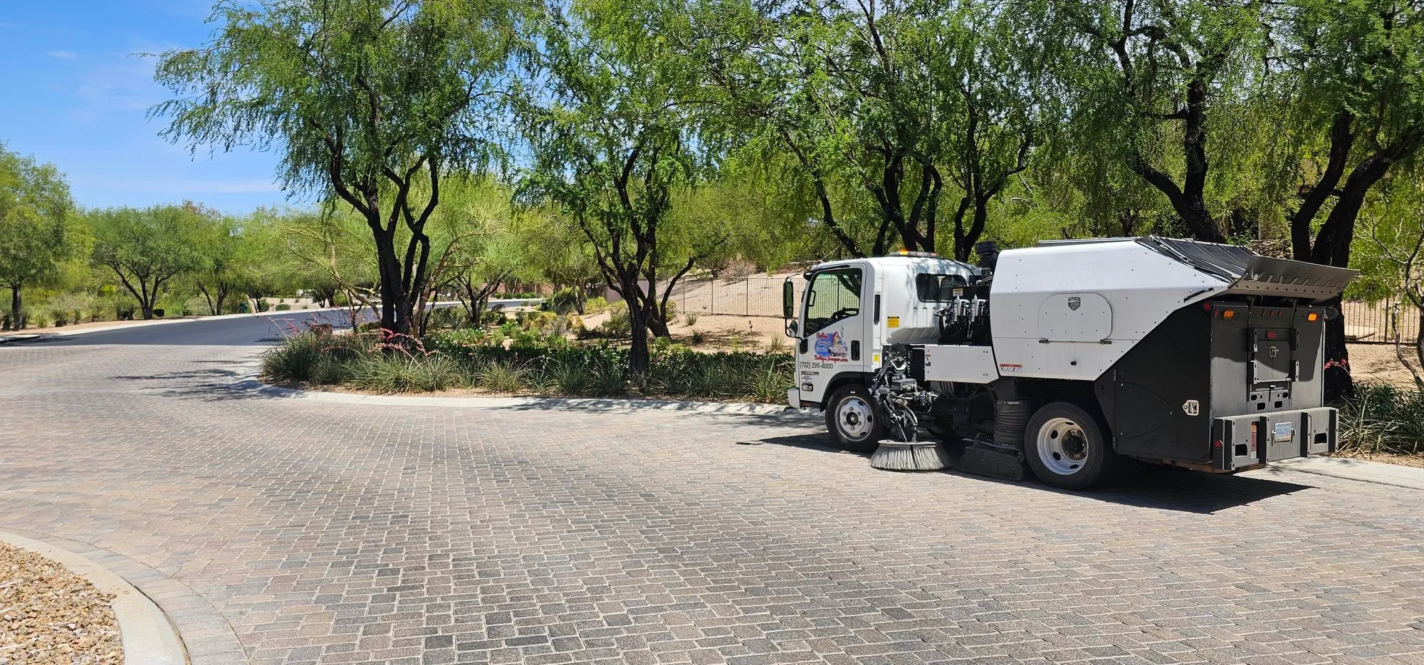 Bailey's sweeper working a paver-laid street through mature landscaping at a premier Las Vegas master-planned community