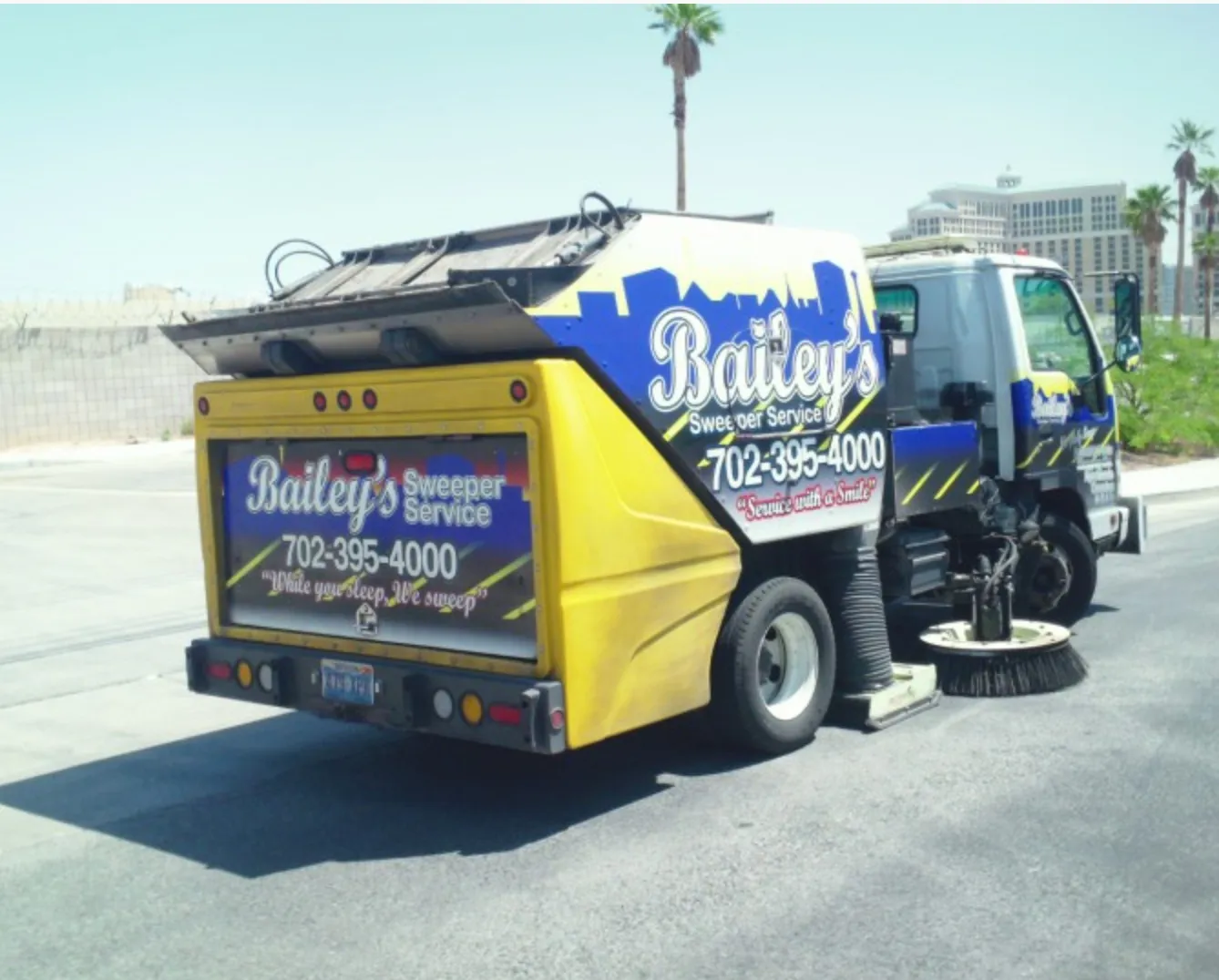 A Bailey's sweeper truck on a Las Vegas Strip side road with Caesars Palace in the background