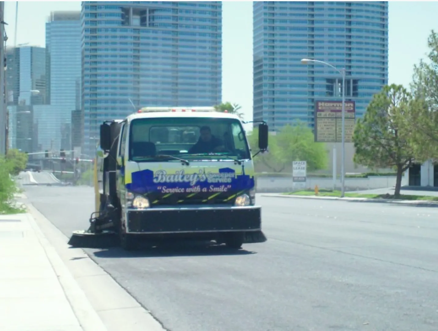 A Bailey's sweeper truck working a Strip street with the CityCenter towers behind