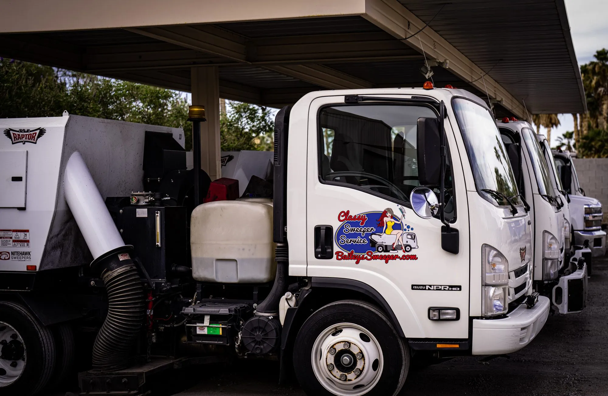 A Bailey's Isuzu street sweeper truck parked at the yard