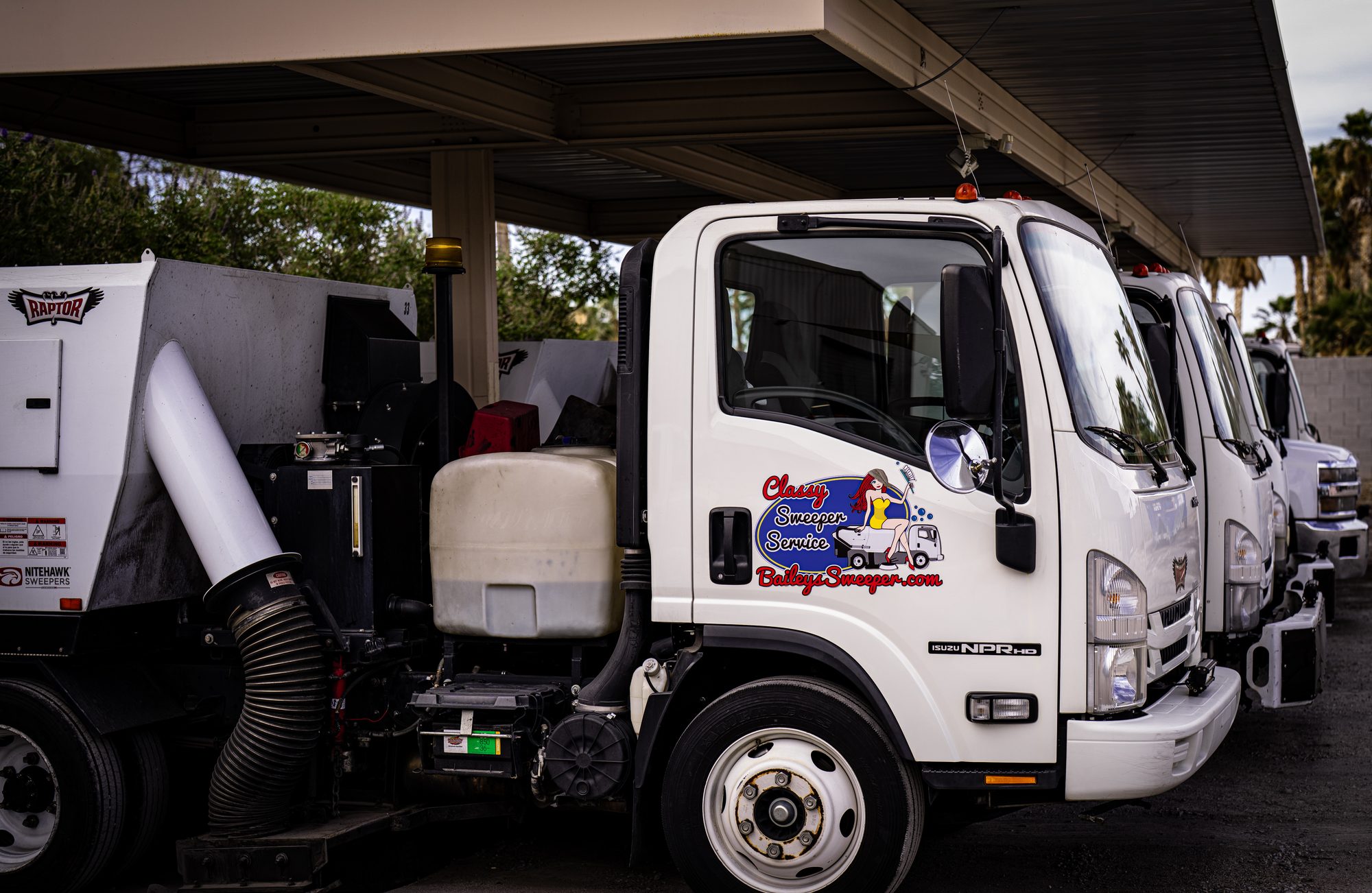 A Bailey's Isuzu street sweeper truck parked at the yard